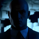 Agent 47 from Hitman standing in the shadows.
